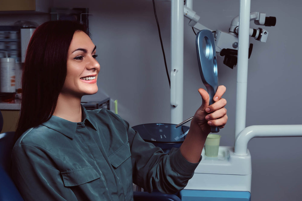 redhead girl sitting in a dentist chair with mirro G2H6MK5 2 1 e1636711817933